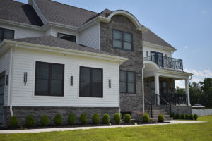 House with white siding and dark grey veneer stone accent walls