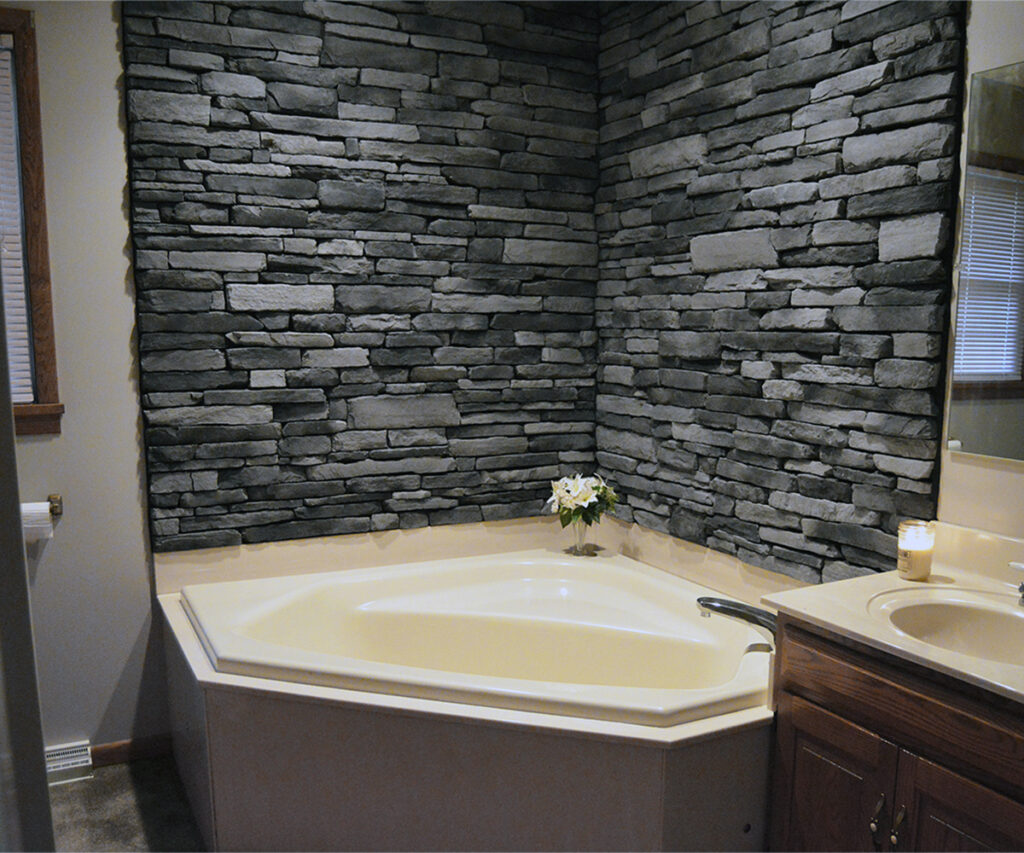 Gray stacked stone bathroom wall showing older gray color trends in interior design.